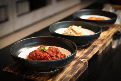 a row of bowls of food on a wooden tray at Utop Ubless Hotel Jeju in Jeju