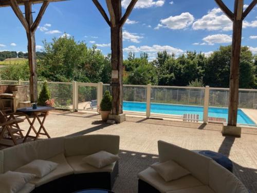 - un salon avec une piscine et un canapé dans l'établissement Gîte familial avec piscine, jardin clos, équipements bébé, animaux acceptés, Chadurie - FR-1-653-61, à Chadurie