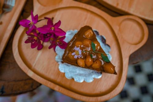 a small dessert on a wooden plate with flowers at Heaven Hill Camping in Ban Thung Na