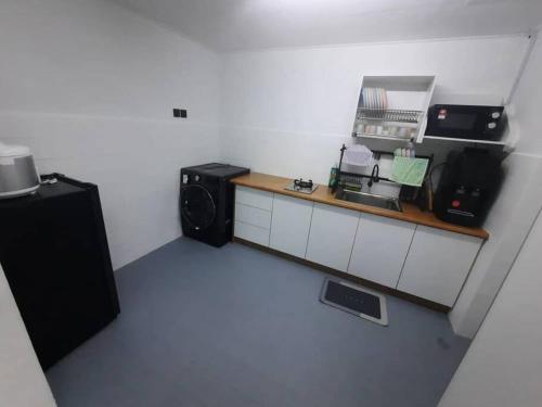 Cette chambre comprend une cuisine équipée d'un comptoir et d'un four micro-ondes. dans l'établissement XHQ Home stay - Bayview b-9-2, à Kampong Baharu