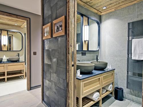 une salle de bain avec deux lavabos et un grand miroir dans l'établissement Appartement familial skis aux pieds au Rond-Point des Pistes, Les Allues - FR-1-613-82, à Les Allues