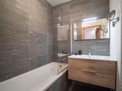 bagno con lavandino, vasca e specchio di Appartement Valmorel, 3 pièces, 7 personnes - FR-1-356-415 a Valmorel