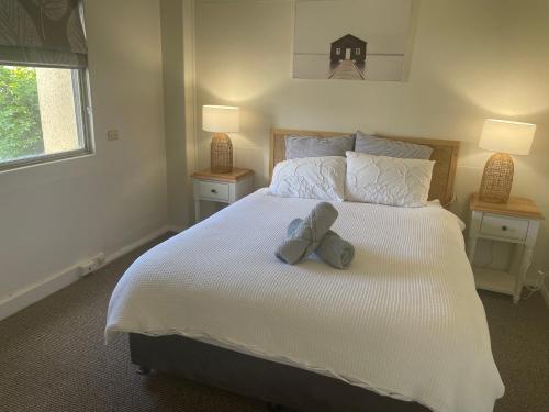 un osito de peluche sentado en una cama con dos lámparas en The Old Flour Mill Apartment (Gallipoli house) en Narrabri