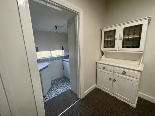 a bathroom with a white cabinet and a closet at The Old Flour Mill Apartment (Gallipoli house) in Narrabri