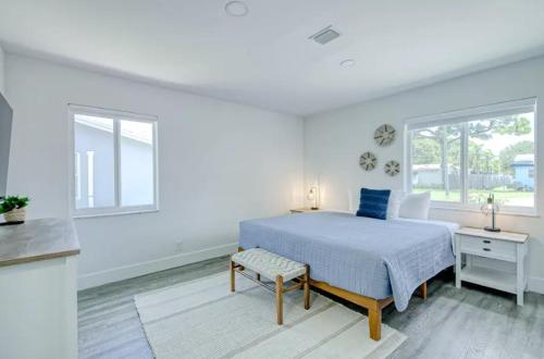a white bedroom with a bed and a table at Blue Cove in Deerfield Beach