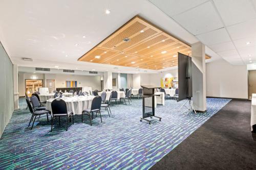 a conference room with tables and chairs and a projection screen at The Colmslie Hotel in Brisbane