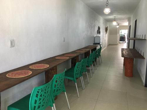 una fila di tavoli e sedie verdi in una stanza di Milagres do Camaragibe a Passo de Camarajibe