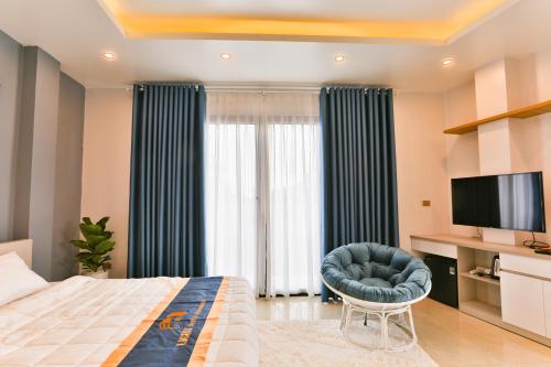 a bedroom with a bed and a chair and a television at Light House - by BAY LUXURY in Hanoi