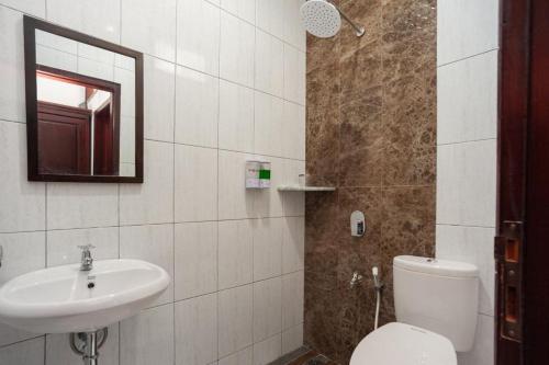 y baño con lavabo, aseo y espejo. en Bethara Hotel Syariah Lampung en Tanjungkarang