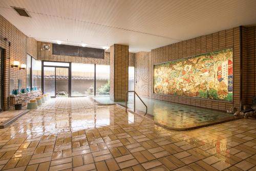 笛吹市にあるIsawa Tokiwa Hotelの大きな絵画が壁に描かれたロビー