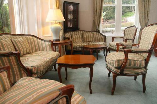 a living room with couches and chairs and a lamp at Sunbank House Metro Hotel in Perth