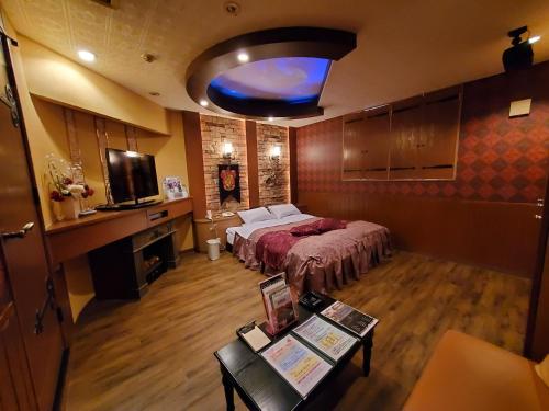 旭川市にあるホテルセリーヌ(大人限定)のベッドとテーブルが備わる広い客室です。