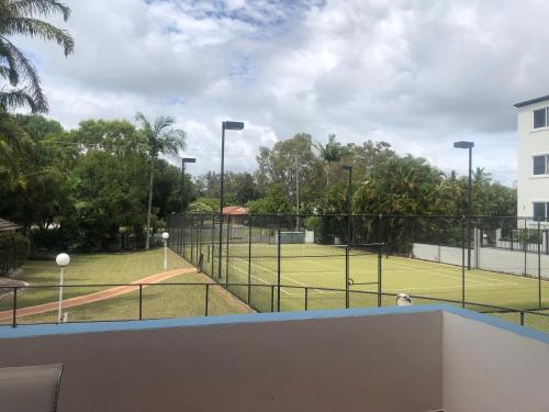 a tennis court with a tennis court at White Crest Apartments in Hervey Bay