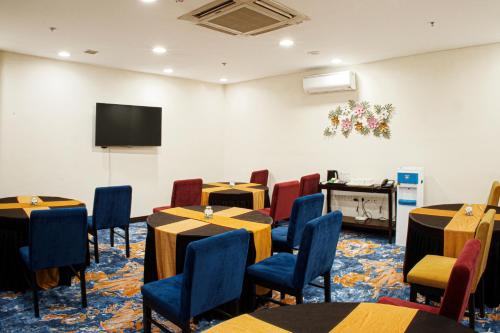 a conference room with tables and chairs and a flat screen tv at Somerset Greenways Chennai in Chennai