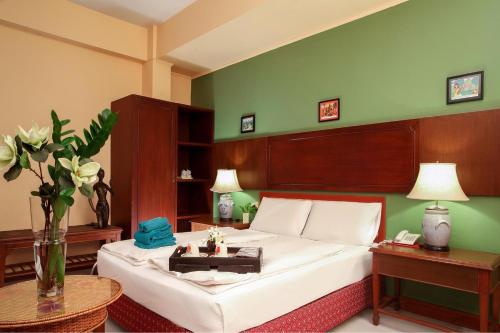 a bedroom with a bed and a green wall at People Place Boutique In Town Hotel - SHA Extra Plus in Chiang Mai