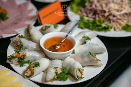 a plate of food with a bowl of dipping sauce at Maya boutique Hotel HN - by BAY LUXURY in Hanoi