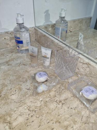 a counter with two bottles of water and a mirror at Alphaville Stadium Residence in Barueri