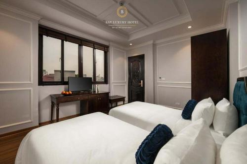 a hotel room with two beds and a television at Maya boutique Hotel HN - by BAY LUXURY in Hanoi