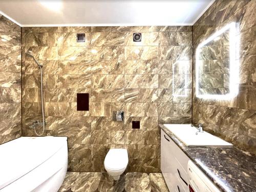 a bathroom with two sinks and a toilet in it at Новостройка с красивым видом 9 этаж in Petropavlovsk