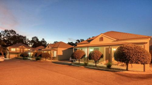 a row of houses with trees in a driveway at Bridges on Meninya Motel & Apartments in Moama