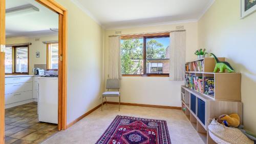 a living room with a kitchen and a mirror at Cape Escape in Cape Paterson