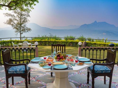 una mesa con comida y vistas a las montañas en Whispering Heights, Pawna Lake, Lonavala - amã Stays & Trails, en Āmbavna