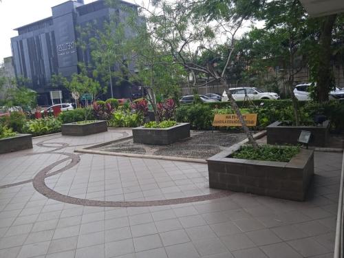 a garden with trees and bushes in a city at Apartemen Pakubuwono Terrace Tipe Studio Jakarta in Jakarta