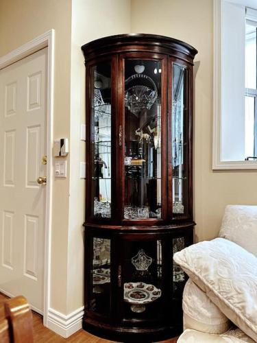 a wooden grandfather clock in a room next to a bed at Super Cosy 8Bed & 6Bath in Vancouver heart near to airport and DownTown in Vancouver