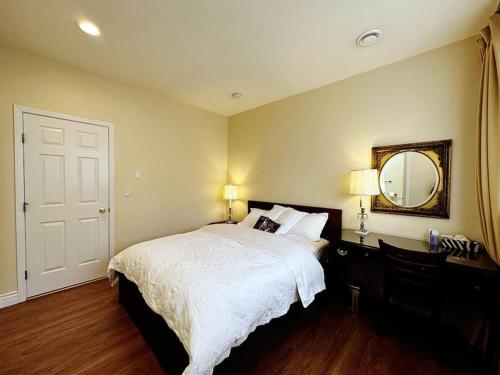 a bedroom with a large bed and a mirror at Super Cosy 8Bed & 6Bath in Vancouver heart near to airport and DownTown in Vancouver