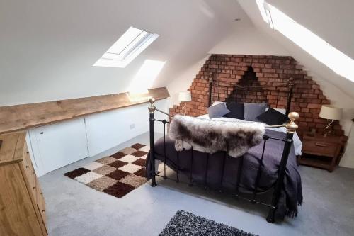 a bedroom with a bed with a brick fireplace at Modern 4-Bedroom Townhouse With Private Garden in Abertillery