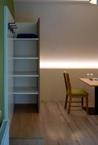 a room with a book shelf and a chair and a table at Pension Christine in Großweikersdorf