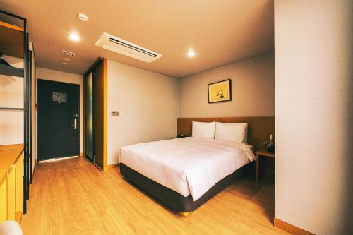 a bedroom with a white bed in a room at Kwangsu Hotel Haeundae in Busan