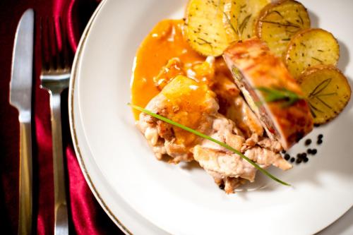 a white plate of food with meat and potatoes at Hotel Mara in Baia Mare
