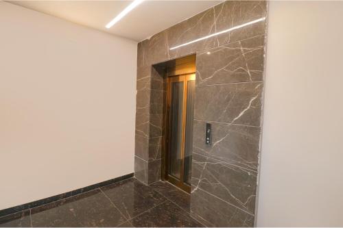 a walk in shower in a room with black tile at Oriva Shanit in New Delhi