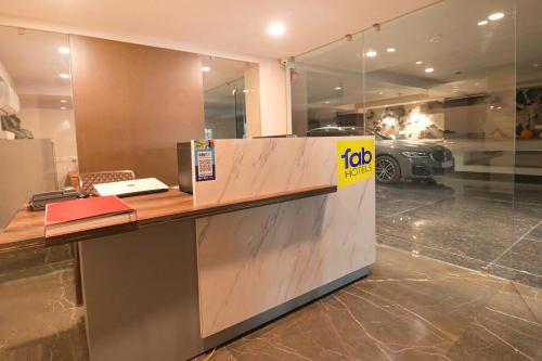 a reception desk with a yellow sign on it at Oriva Shanit in New Delhi