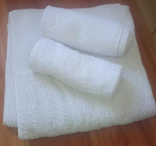 a pile of white towels on a wooden floor at BreezHub Residence in Kikambala
