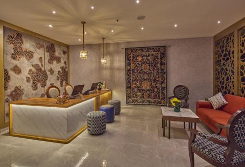 a lobby with a reception desk and a couch at Golden Tulip Tirupati in Tirupati