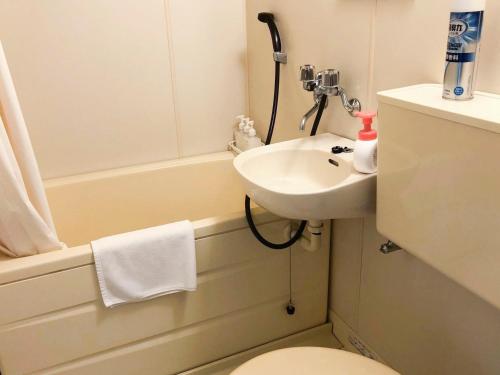 uma casa de banho com um lavatório, um WC e uma banheira em Pension Todoroki em Atami