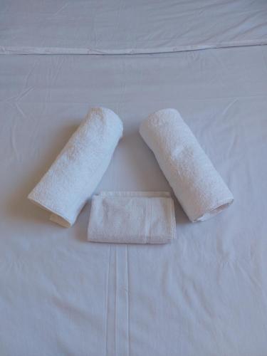 twee witte handdoeken zittend op een bed bij sky furnished apartment in south b in Nairobi
