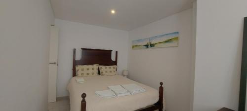 een slaapkamer met een bed met witte lakens en kussens bij 20 Casa da Aldeia in Alfarim