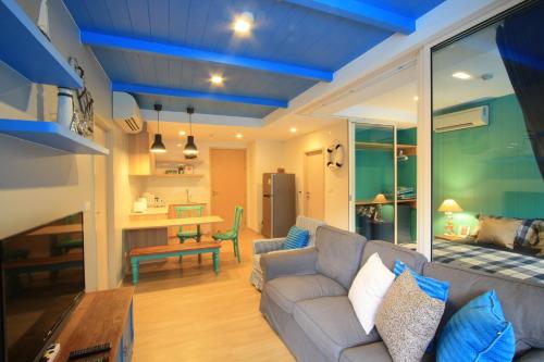 uma sala de estar com um sofá e uma mesa em บ้านแสนคราม หัวหิน Family Room - Pool Access ห้องติดสระ em Phetchaburi