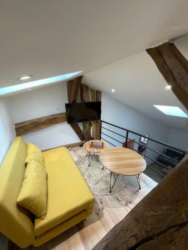 sala de estar con sofá amarillo y mesa en Le nid de bois - Centre ville - WIFI/SMART TV, en Casteljaloux