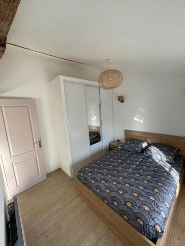 ein kleines Schlafzimmer mit einem Bett und einer Tür in der Unterkunft Le nid de bois - Centre ville - WIFI/SMART TV in Casteljaloux