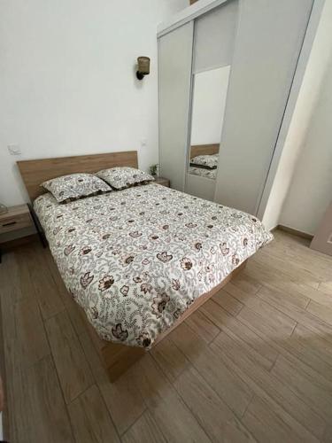 1 dormitorio con cama y espejo. en Le nid de bois - Centre ville - WIFI/SMART TV, en Casteljaloux