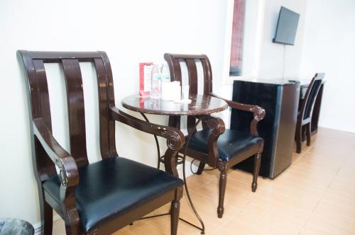 a wooden table with chairs and a small table with drinks on it at Hotel Euroasia By BLUEBOOKERS in Angeles