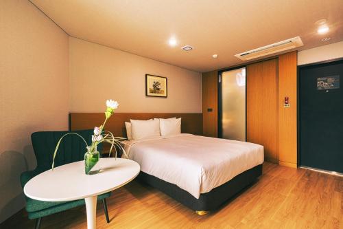 a hotel room with a bed and a table at Kwangsu Hotel Haeundae in Busan