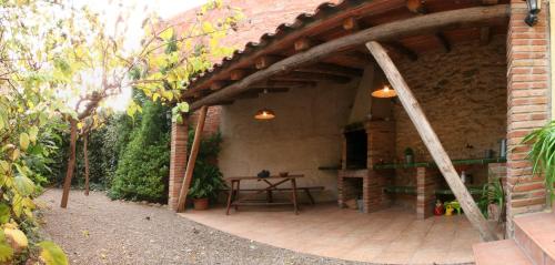 un patio al aire libre con una mesa y un edificio de ladrillo en Cal Conrad, en Nulles