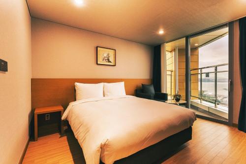 a bedroom with a large bed and a window at Kwangsu Hotel Haeundae in Busan