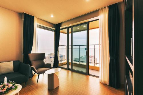 a living room with a couch and a large window at Kwangsu Hotel Haeundae in Busan