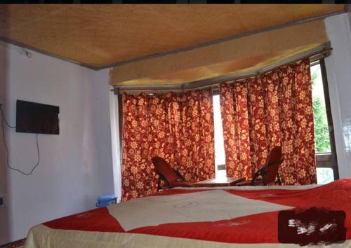 - une chambre avec un lit, deux chaises et une fenêtre dans l'établissement Grand Heritage Resort, à Pahalgām